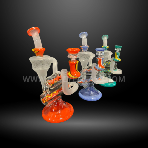 Set of four colorful frosted glass recycler rigs with patterned accents and vibrant bases in red, blue, green, and multicolor designs. Wholesale water pipes.