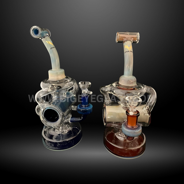 Two recycler-style glass bongs with dual-tone accents in blue and red. Compact, durable wholesale water pipes designed for smoke shops and distributors.
