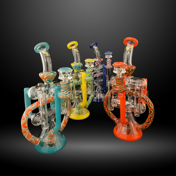Set of four recycler-style glass bongs with swirl accents in yellow, blue, teal, and orange. Premium wholesale water pipes for head shops and distributors.