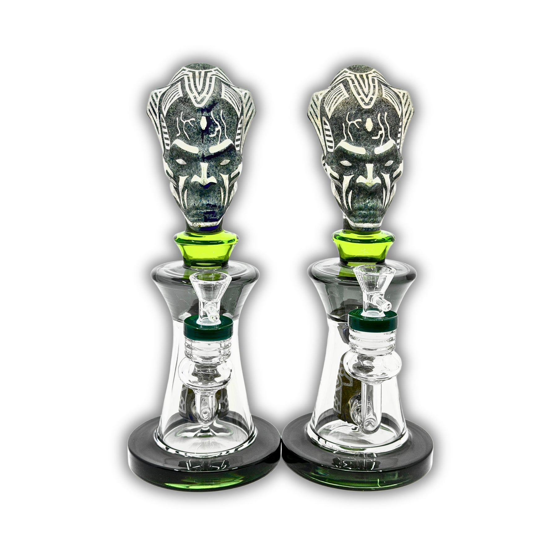 Decorative glass bong featuring a tribal warrior head sculpture, clear chamber body, and matching green accent details with removable bowl.