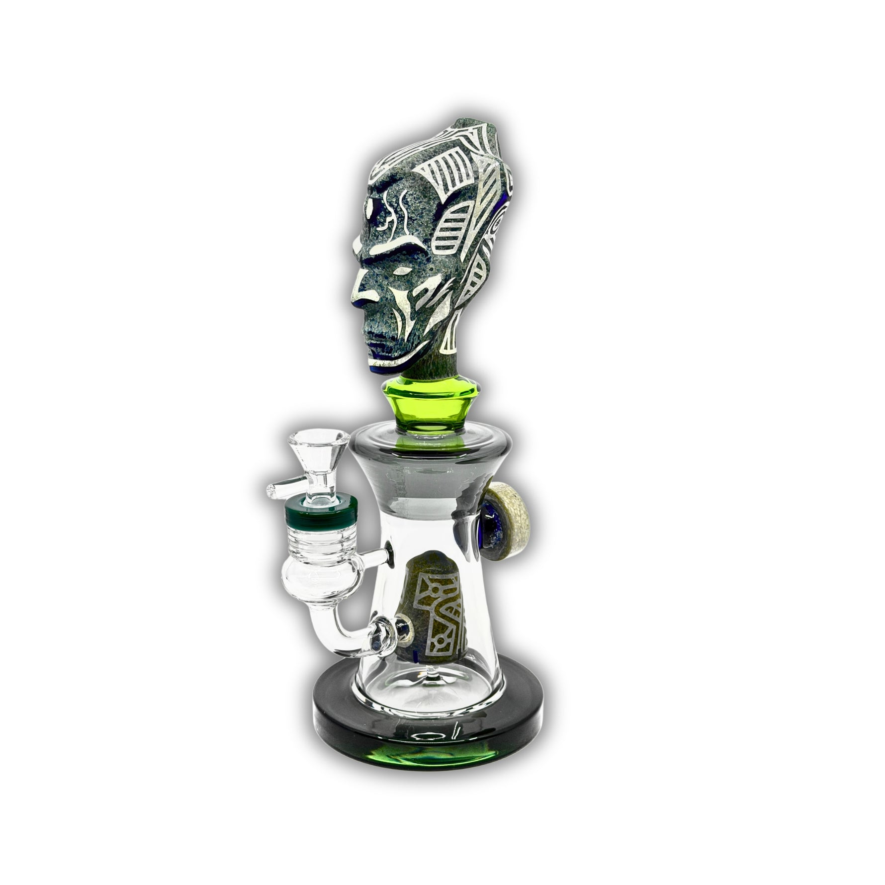 Decorative glass bong featuring a tribal warrior head sculpture, clear chamber body, and matching green accent details with removable bowl.