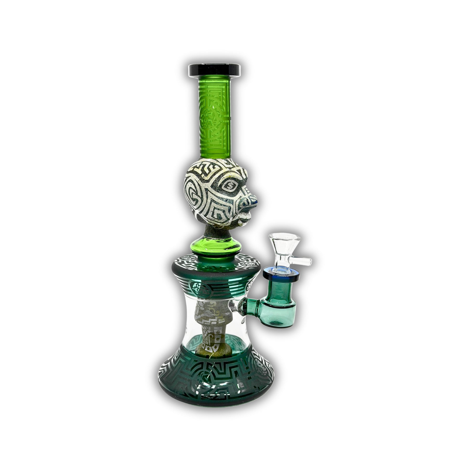 Decorative glass water pipe featuring carved tribal face artwork, frosted etched patterns, emerald green neck tubing, and detailed geometric base accents.