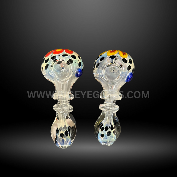 Assorted 4-inch glass hand pipes featuring spotted black and colored dot designs on clear glass with decorative accents. Wholesale pipes for smoke shops and head shops.