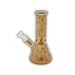 Assorted mini glass beaker bongs featuring frosted finishes, metallic electroplated colors, engraved paisley and skull patterns, cannabis leaf graphics, and decorative etched designs.