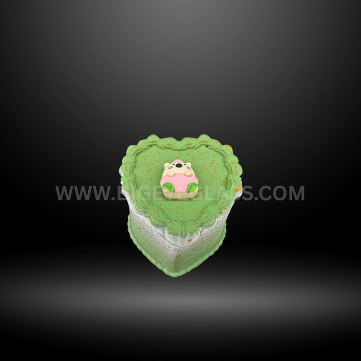 Green cake-shaped herb grinders in heart and square designs with detailed frosting tops and layered colors. Fun novelty grinders for smoking accessories